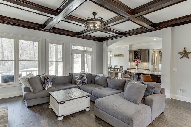 living room featuring french doors, dark hardwood / wood-style flooring, coffered ceiling, beamed ceiling, and crown molding