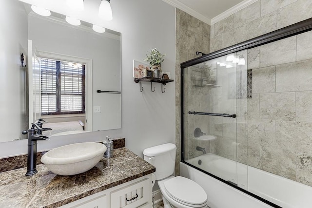 full bathroom featuring ornamental molding, vanity, bath / shower combo with glass door, and toilet