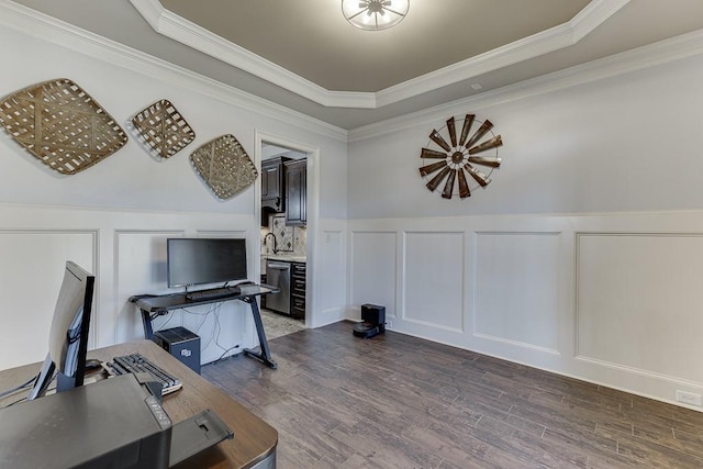 home office with a tray ceiling, sink, dark wood-type flooring, and crown molding