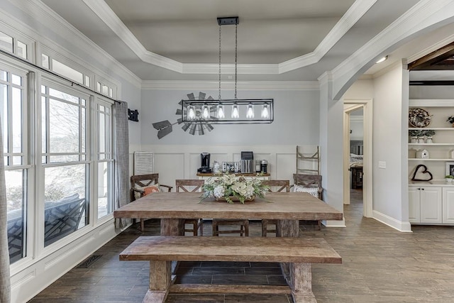 dining space featuring a tray ceiling, ornamental molding, dark hardwood / wood-style floors, and built in features