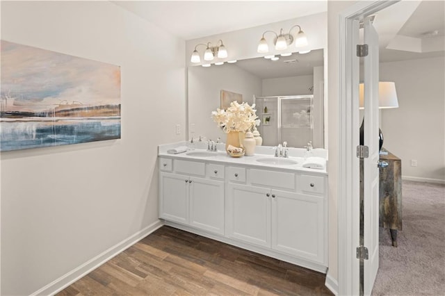 bathroom featuring vanity, wood-type flooring, and a shower with shower door