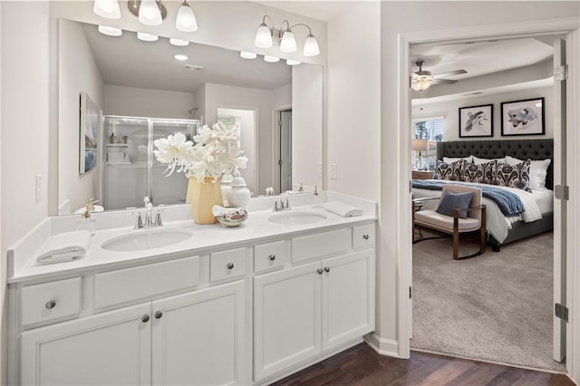 bathroom with a shower with door, vanity, wood-type flooring, and ceiling fan