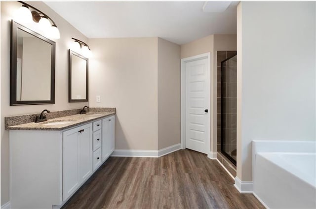 bathroom featuring hardwood / wood-style floors, vanity, and shower with separate bathtub