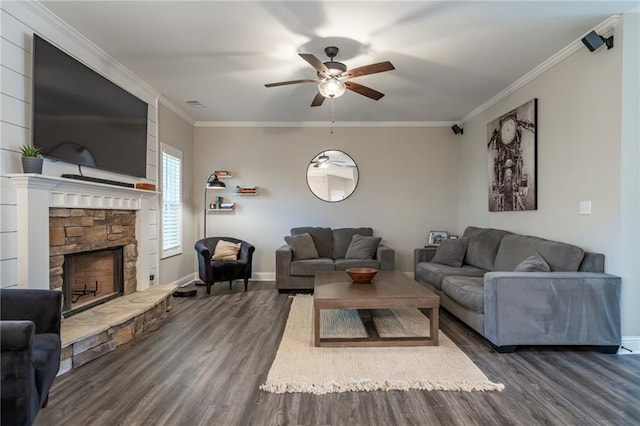 living room with crown molding, a fireplace, ceiling fan, and dark wood-type flooring