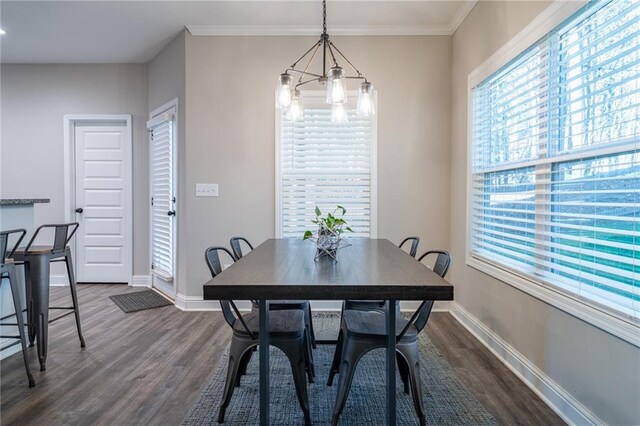 dining room featuring crown molding, dark hardwood / wood-style flooring, and an inviting chandelier