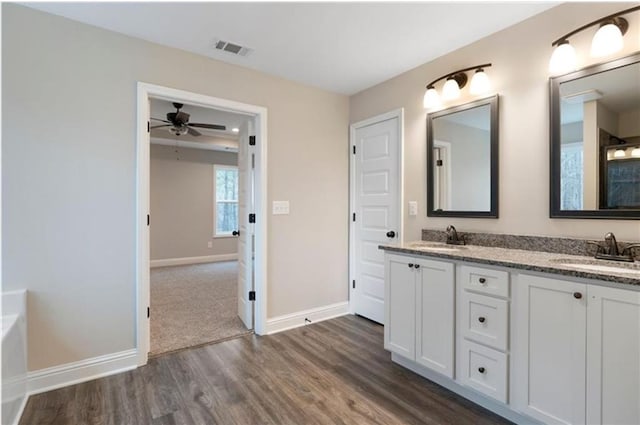 bathroom with hardwood / wood-style floors, vanity, and ceiling fan