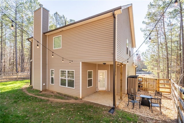 back of house featuring a patio area and a lawn