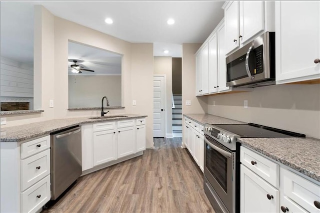 kitchen featuring sink, white cabinets, light hardwood / wood-style flooring, and appliances with stainless steel finishes