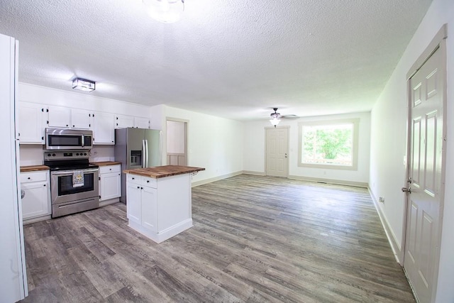 178 Wayne St SW, Calhoun, GA 30701 - kitchen with wooden counters, stainless steel appliances, a textured ceiling, and white cabinetry