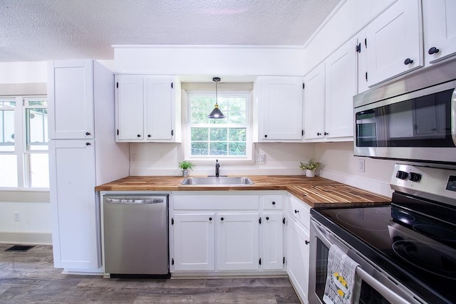 178 Wayne St SW, Calhoun, GA 30701 - kitchen with appliances with stainless steel finishes, a sink, butcher block counters, a textured ceiling, and white cabinetry