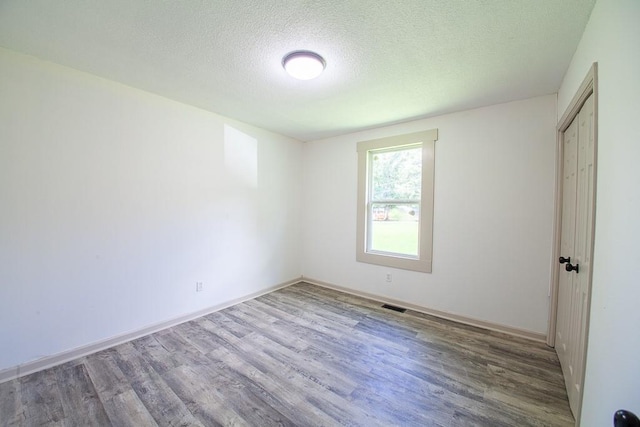 178 Wayne St SW, Calhoun, GA 30701 - unfurnished bedroom featuring wood finished floors, a textured ceiling, and baseboards