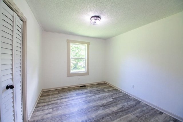 178 Wayne St SW, Calhoun, GA 30701 - unfurnished bedroom with a textured ceiling, wood finished floors, and baseboards