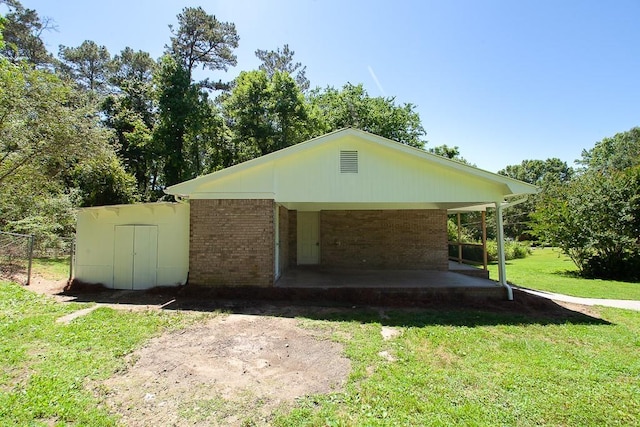 178 Wayne St SW, Calhoun, GA 30701 - view of property exterior featuring brick siding, a lawn, a carport, driveway, and a patio