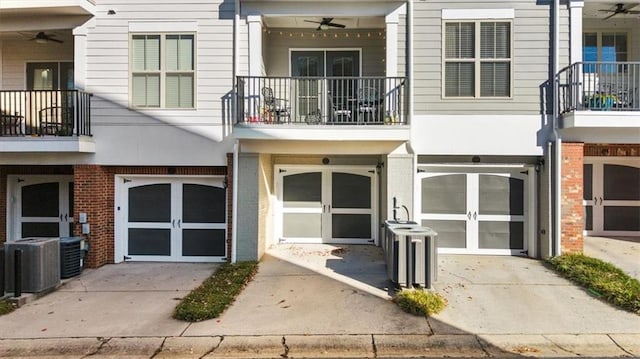 view of exterior entry featuring central AC unit and ceiling fan