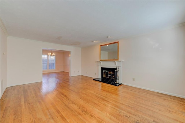 unfurnished living room with crown molding, light hardwood / wood-style floors, and a chandelier