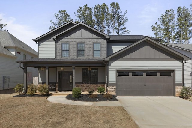 craftsman inspired home featuring board and batten siding, a porch, a garage, stone siding, and driveway