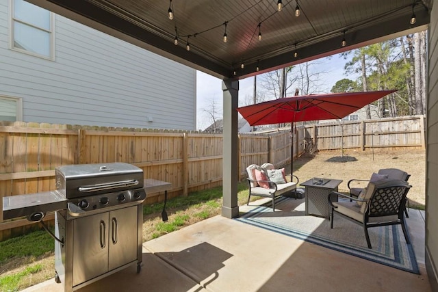 view of patio with grilling area, an outdoor hangout area, and a fenced backyard