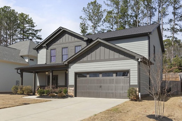 craftsman-style home with board and batten siding, fence, covered porch, a garage, and driveway