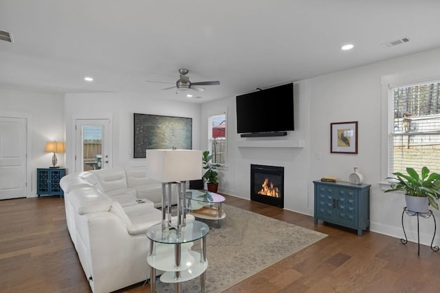 living room with recessed lighting, visible vents, a large fireplace, and wood finished floors