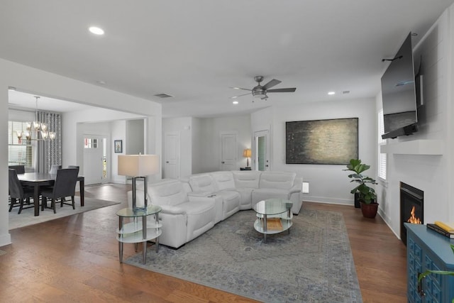 living area with recessed lighting, baseboards, a large fireplace, and wood finished floors