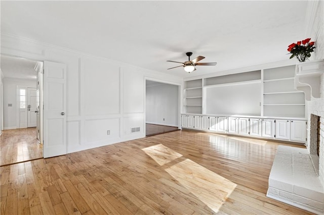 unfurnished living room with ornamental molding, light hardwood / wood-style floors, and ceiling fan