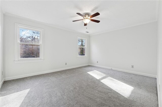 empty room with ceiling fan, ornamental molding, and carpet