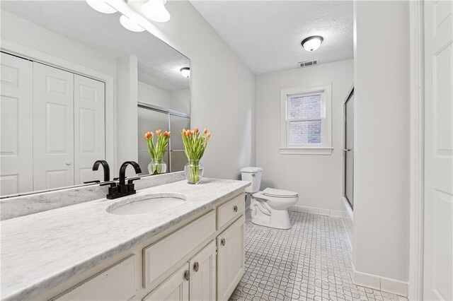 bathroom with toilet, tile patterned flooring, and combined bath / shower with glass door