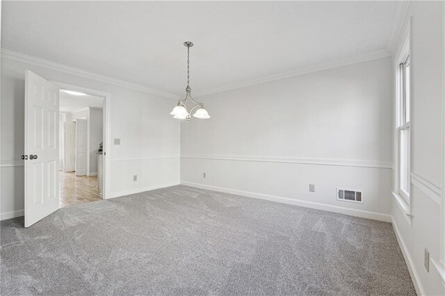 carpeted empty room featuring crown molding and a notable chandelier