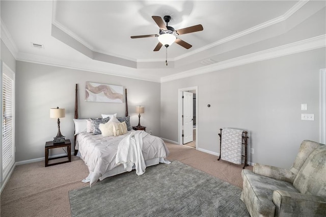 carpeted bedroom featuring visible vents, baseboards, a raised ceiling, and crown molding