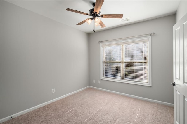 carpeted spare room with a ceiling fan, visible vents, and baseboards