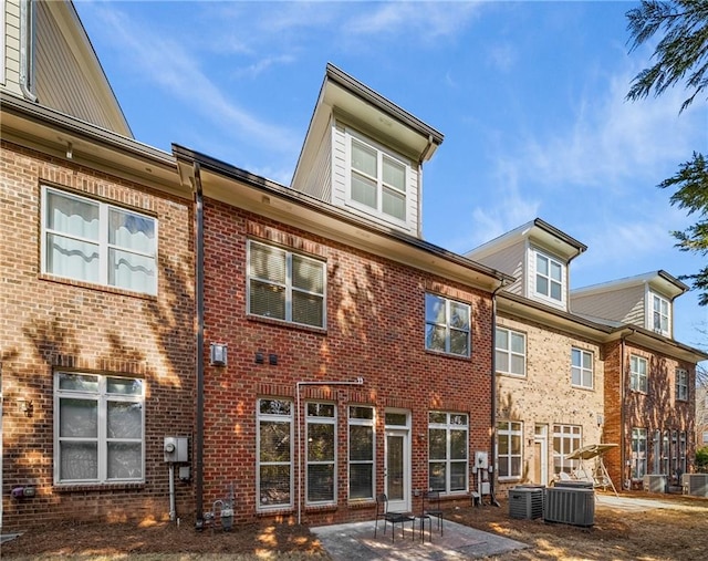 back of property featuring brick siding, a patio area, and cooling unit