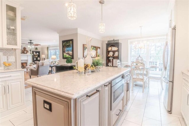 3 Westridge Pl, Rome, GA 30165 - kitchen with stainless steel microwave, decorative light fixtures, white cabinetry, ornamental molding, and a center island