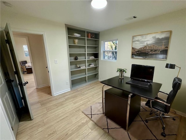 office with baseboards, visible vents, and light wood-style floors