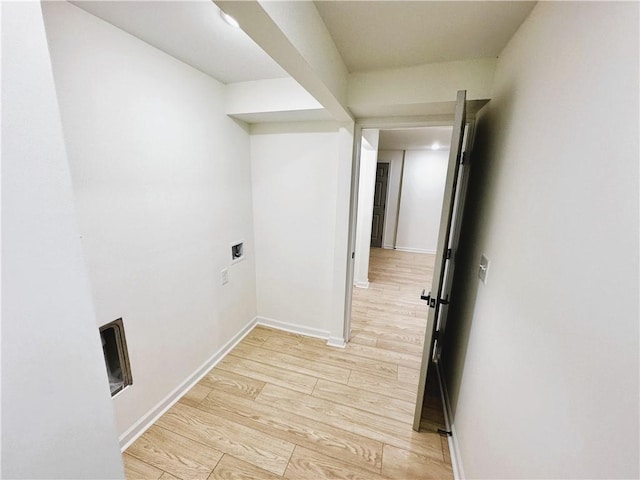 hall with light wood-style flooring and baseboards