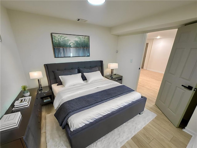 bedroom with light wood finished floors and visible vents