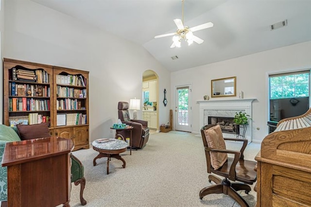 home office with ceiling fan, a fireplace, high vaulted ceiling, and light carpet