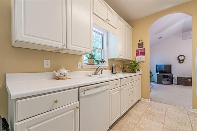 kitchen featuring white dishwasher, sink, white cabinetry, and light tile patterned flooring