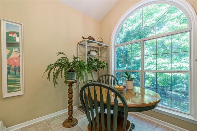 tiled dining area featuring lofted ceiling