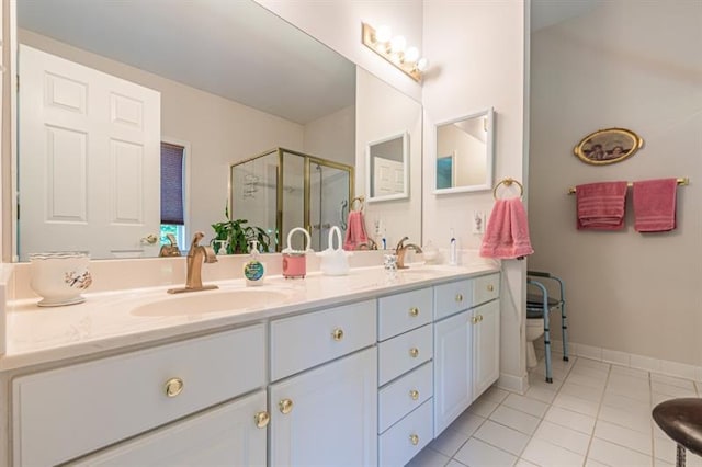 bathroom featuring vanity, a shower with shower door, and tile patterned flooring