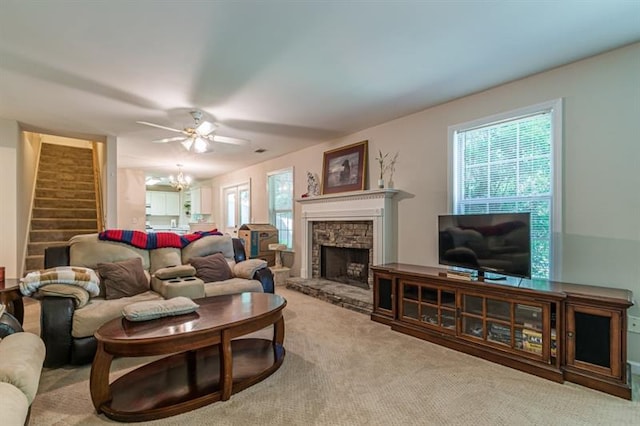 carpeted living room featuring a fireplace and ceiling fan