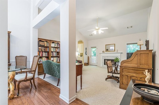 sitting room featuring ceiling fan, high vaulted ceiling, a premium fireplace, and light hardwood / wood-style floors