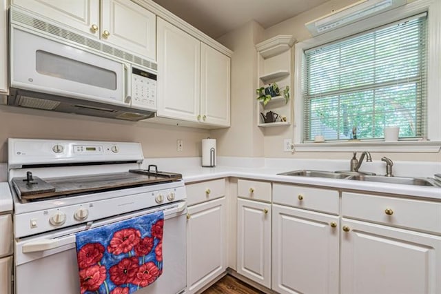 kitchen featuring white appliances, sink, and white cabinets