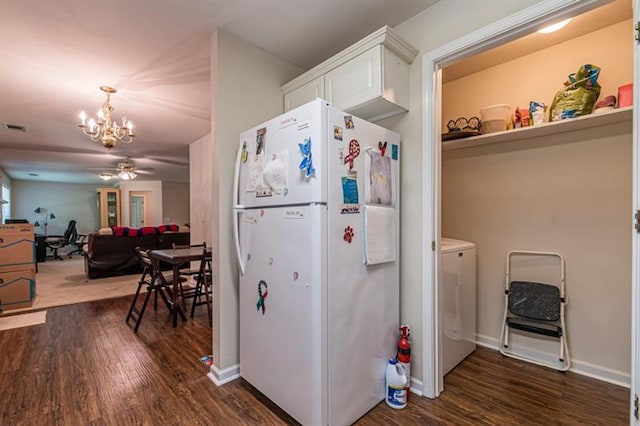 kitchen featuring dark hardwood / wood-style floors, ceiling fan with notable chandelier, washer / clothes dryer, white cabinets, and white refrigerator