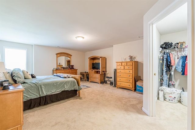 bedroom featuring light carpet and a closet