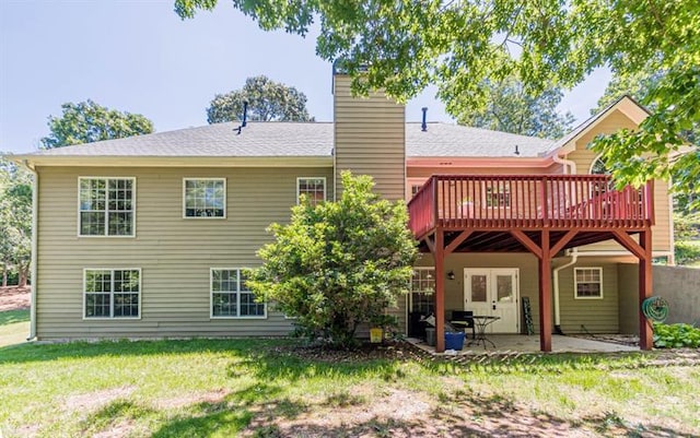 back of property with a wooden deck, a yard, and a patio area