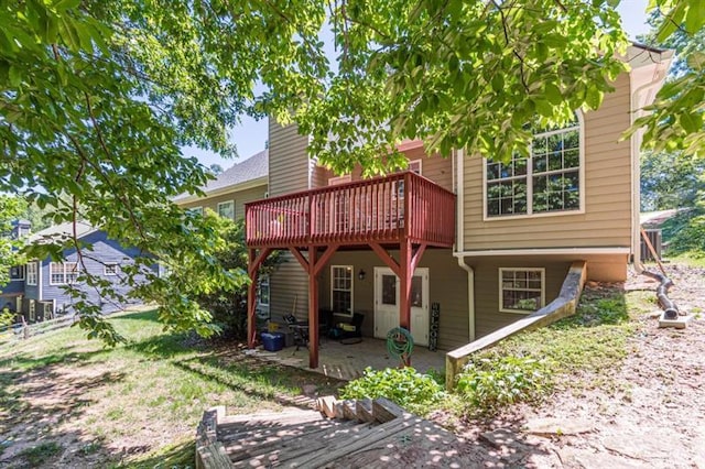 back of property featuring a wooden deck and a patio area