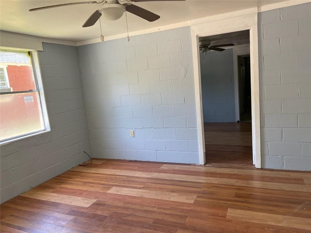 unfurnished room with wood-type flooring and ceiling fan