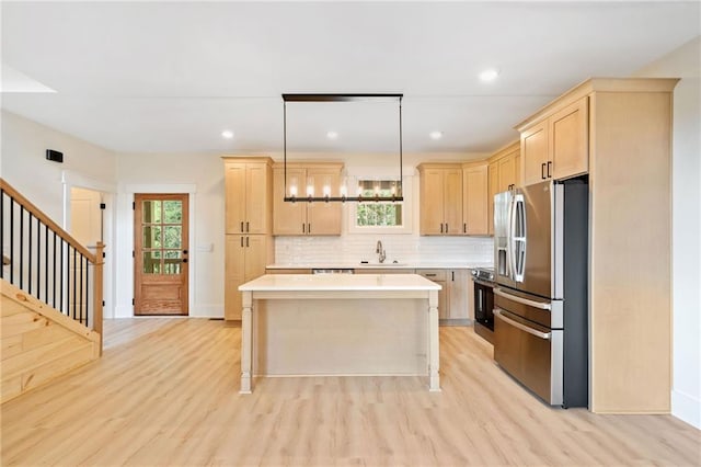 kitchen featuring a healthy amount of sunlight, appliances with stainless steel finishes, pendant lighting, and sink