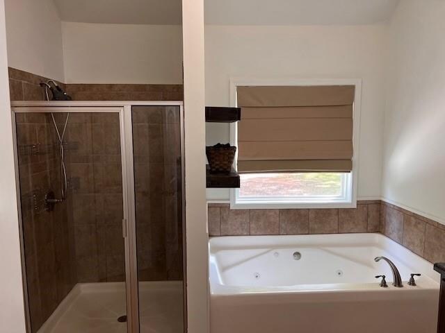 bathroom featuring shower with separate bathtub