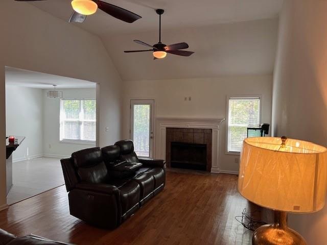 living room featuring ceiling fan, hardwood / wood-style flooring, vaulted ceiling, and a wealth of natural light